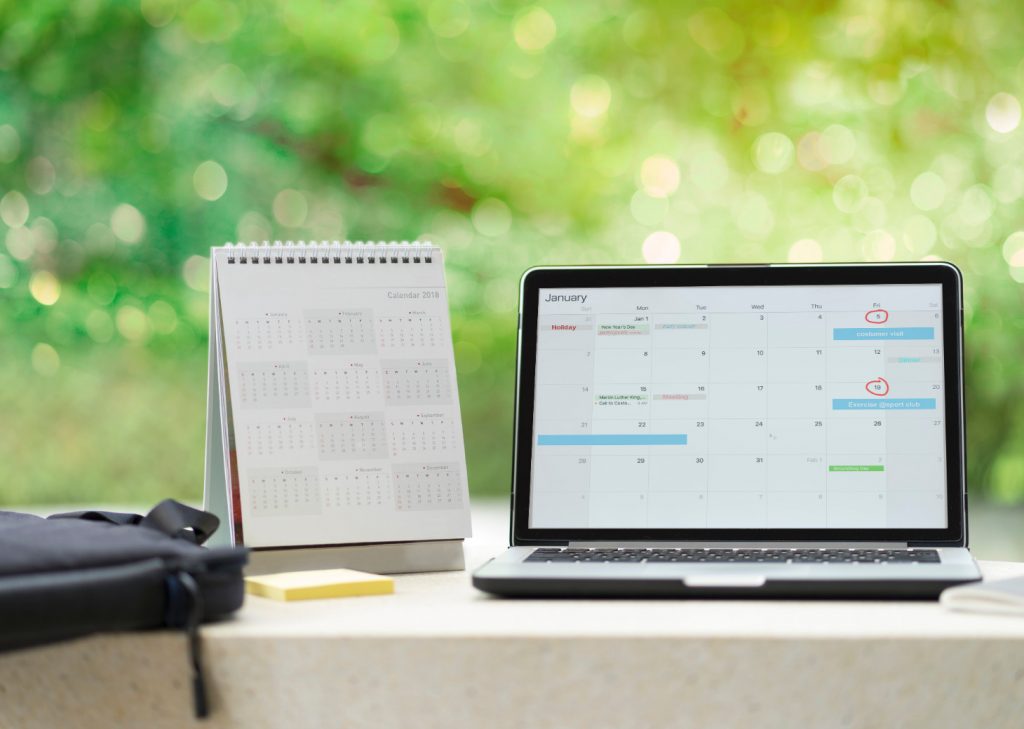 A modern individual scheduling an appointment via his laptop. 