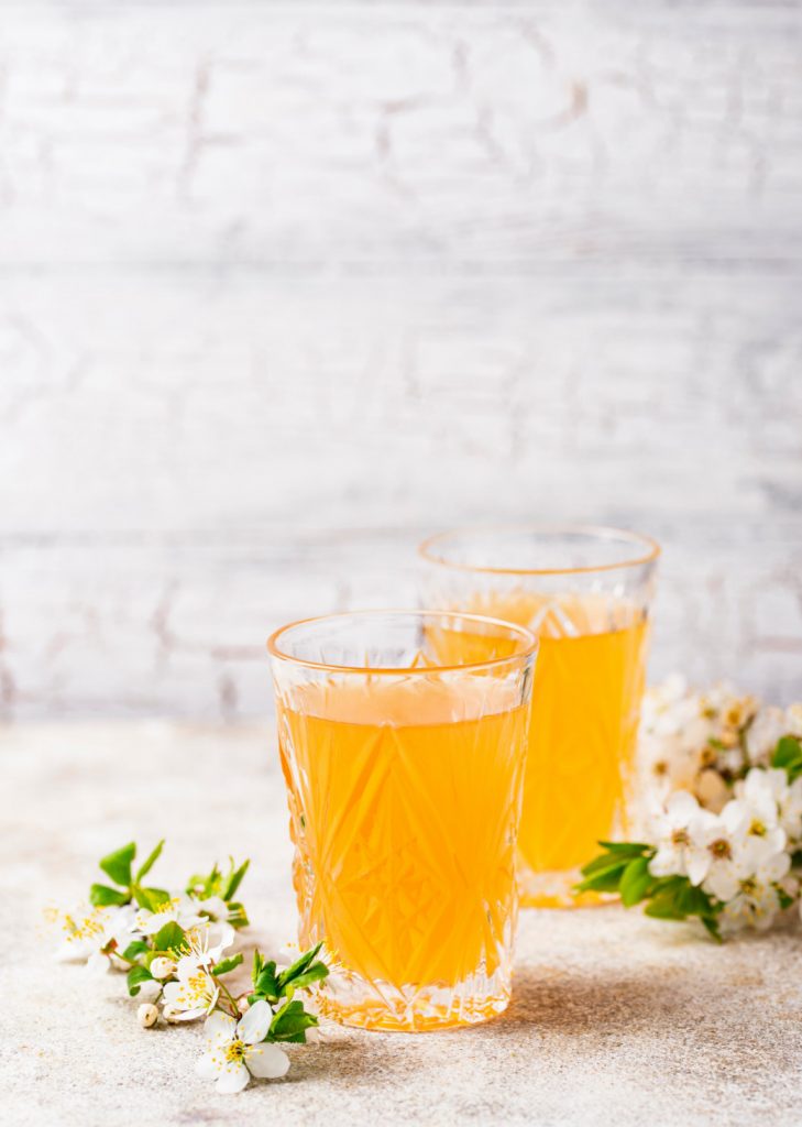 Orange juice in two glasses is kept on a table.