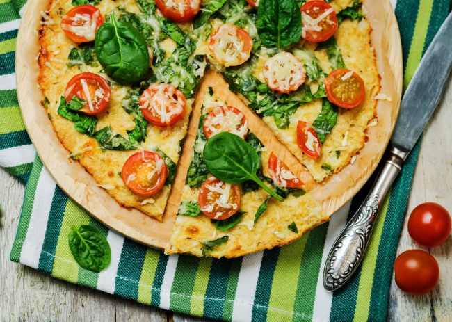 Cauliflower pizza crust with tomato and spinach