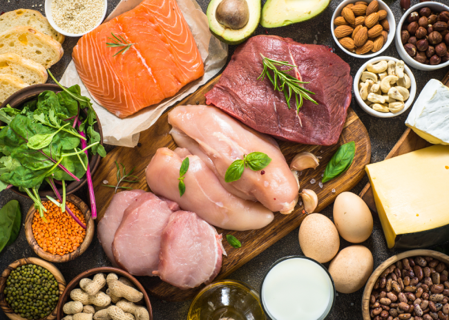 Salmon fish along with Chicken and eggs are kept on a wooden board.